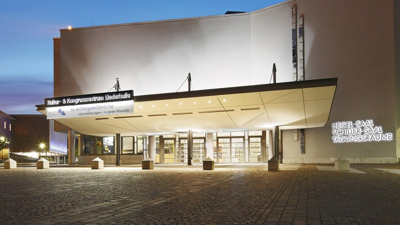Eingang der Liederhalle Stuttgart bei D&auml;mmerung, beleuchtet mit Schildern f&uuml;r Hegel-Saal, Schiller-Saal und Tagungsr&auml;ume., &copy; Kultur- und Kongresszentrum Liederhalle