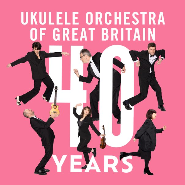 Sechs Personen in Anzügen posieren auf einem pinken Hintergrund mit der Aufschrift 'Ukulele Orchestra of Great Britain 40 Years'., © Theaterhaus Stuttgart e.V. Sechs Personen in Anzügen posieren auf einem pinken Hintergrund mit der Aufschrift 'Ukulele Orchestra of Great Britain 40 Years'., © Theaterhaus Stuttgart e.V.