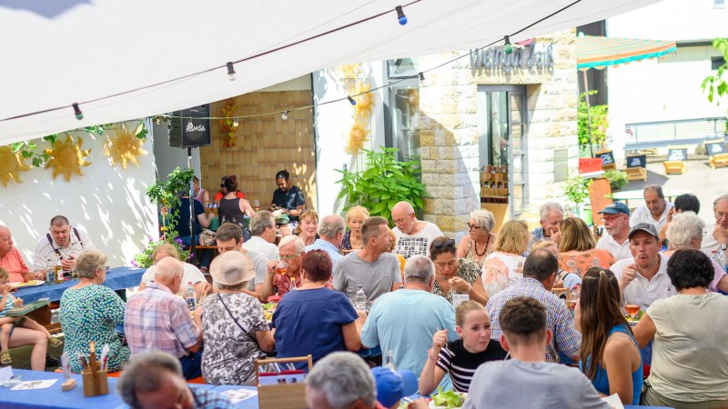 Geselliges Beisammensein im Freien bei Weingut Zai&szlig;. Menschen genie&szlig;en Essen und Getr&auml;nke unter einem Sonnensegel., &copy; Weingut Zai&szlig;