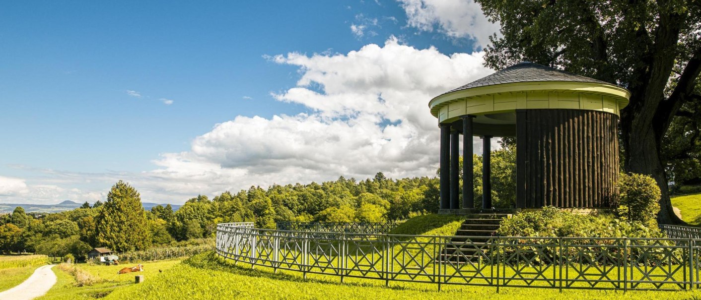 A round pavilion on a hill, surrounded by green countryside and a blue sky with clouds. A path leads through the meadow., © SMG Stuttgart Marketing GmbH - Sarah Schmid A round pavilion on a hill, surrounded by green countryside and a blue sky with clouds. A path leads through the meadow., © SMG Stuttgart Marketing GmbH - Sarah Schmid