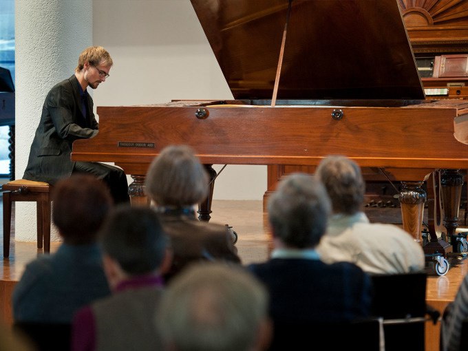 Ein Pianist spielt auf einem Fl&uuml;gel vor einem sitzenden Publikum in einem Konzertsaal., &copy; Landesmuseum W&uuml;rttemberg