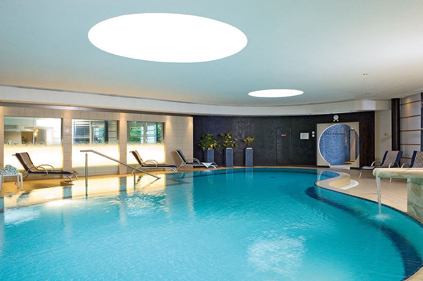 Moderner Innenpool mit Liegestühlen und Pflanzen im Pullman Stuttgart Fontana Hotel., © Pullman Stuttgart Fontana