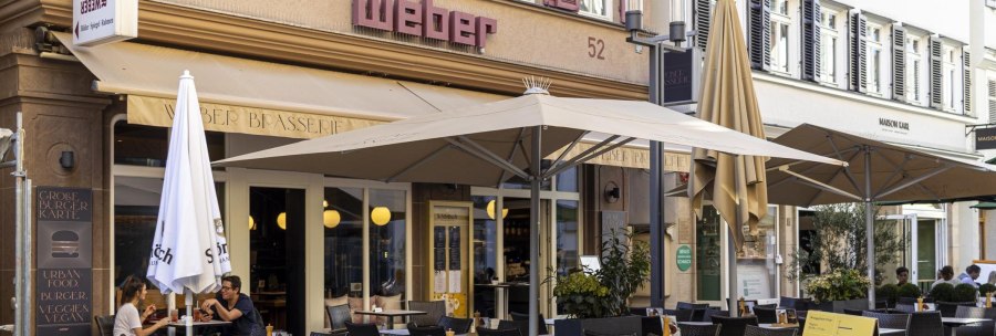 A caf&eacute; called 'Weber' has an outdoor area with tables, chairs and parasols. People sit and enjoy drinks., &copy; SMG, Sarah Schmid
