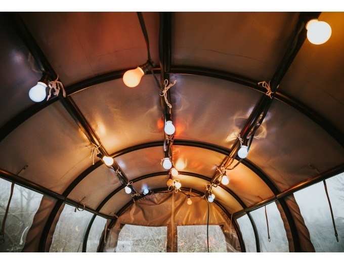 Innenansicht eines Zeltdachs mit bunten Lichtern, die an den Streben befestigt sind. Die Lichter schaffen eine warme Atmosph&auml;re., &copy; Cool-Tours StattReisen