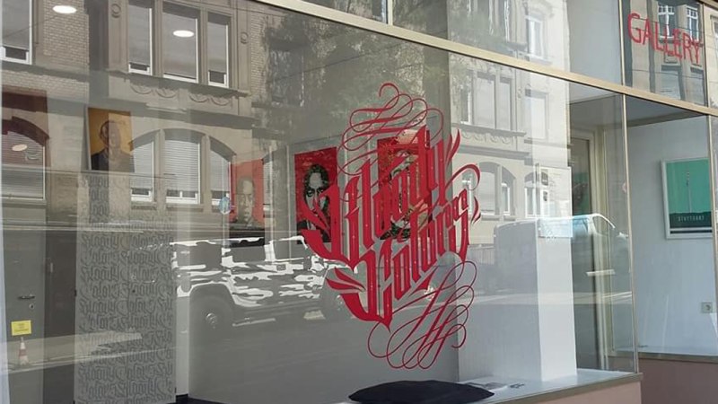 Schaufenster der Bloody Colors Gallery mit rotem Schriftzug und Spiegelung der gegenüberliegenden Gebäude., © Horst Krick