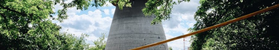Ein Winkelturm mit rotem Dach umgeben von B&auml;umen, unter einem blauen Himmel. Menschen gehen auf einem gepflasterten Weg., &copy; tmbw, Susi Maier