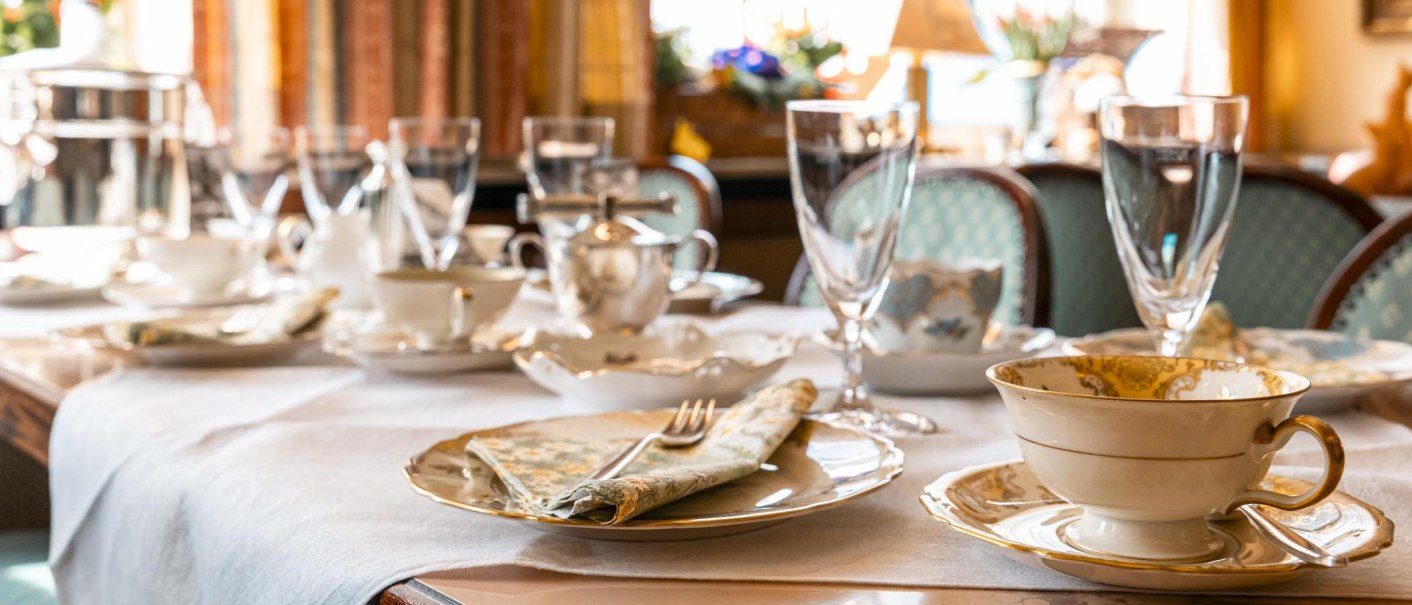 Ein elegant gedeckter Tisch mit feinem Porzellan, Gläsern und Besteck in einem gemütlichen Café-Ambiente., © Stuttgart Marketing GmbH, Sarah Schmid