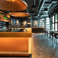 Modern caf&eacute; with bar, illuminated shelves full of bottles, glasses and seating areas. Large windows let in plenty of light., &copy; Maks Richter
