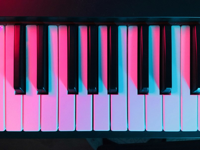 Piano keys in close-up, illuminated by blue and pink light, which creates an atmospheric effect., &copy; Collegium Wirtemberg
