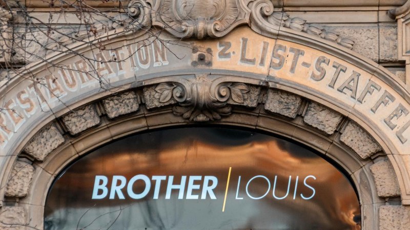 Detail einer historischen Gebäudefassade mit der Aufschrift 'BROTHER LOUIS' in einem modernen Schaufenster., © Stuttgart-Marketing GmbH, Sarah Schmid Detail einer historischen Gebäudefassade mit der Aufschrift 'BROTHER LOUIS' in einem modernen Schaufenster., © Stuttgart-Marketing GmbH, Sarah Schmid
