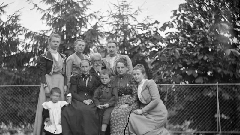 Eine historische Fotografie zeigt eine Familie mit neun Personen, darunter Erwachsene und Kinder, vor einem Zaun und Bäumen. Die Kleidung wirkt aus dem 19. Jahrhundert., © Landesarchiv Baden-Württemberg HStAS Q 2/48 Bü 60 Nr. 3, 1 Glasplatte