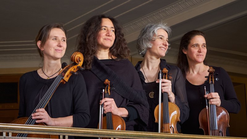 Vier Musikerinnen des Anthea Quartetts stehen mit ihren Streichinstrumenten auf einem Balkon und lächeln in die Ferne., © Mendelssohn Quartett Vier Musikerinnen des Anthea Quartetts stehen mit ihren Streichinstrumenten auf einem Balkon und lächeln in die Ferne., © Mendelssohn Quartett