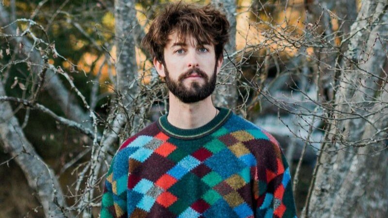 Ein Mann mit buntem Pullover steht vor kahlen B&auml;umen. Er hat dunkles Haar und einen Bart. Die Umgebung wirkt herbstlich., &copy; Stuttgarter Kammerorchester e.V.