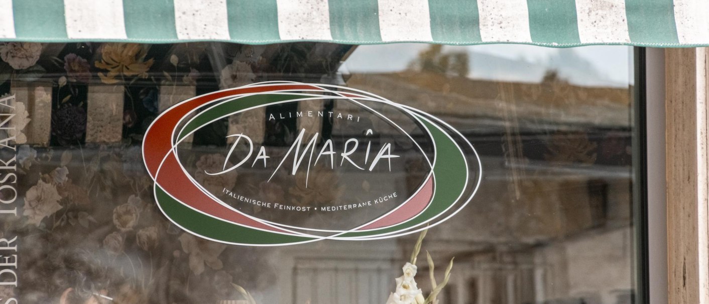 Shop window with the logo of "Alimentari Da Maria". It displays Italian colors and offers Italian delicatessen and Mediterranean cuisine., © SMG Stuttgart Marketing GmbH - Sarah Schmid