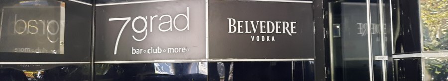 Eingang zur 7grad Bar mit schwarzem Interieur und Belvedere Vodka Werbung. Glastür mit "Ziehen"-Schild sichtbar., © SMG Eingang zur 7grad Bar mit schwarzem Interieur und Belvedere Vodka Werbung. Glastür mit "Ziehen"-Schild sichtbar., © SMG
