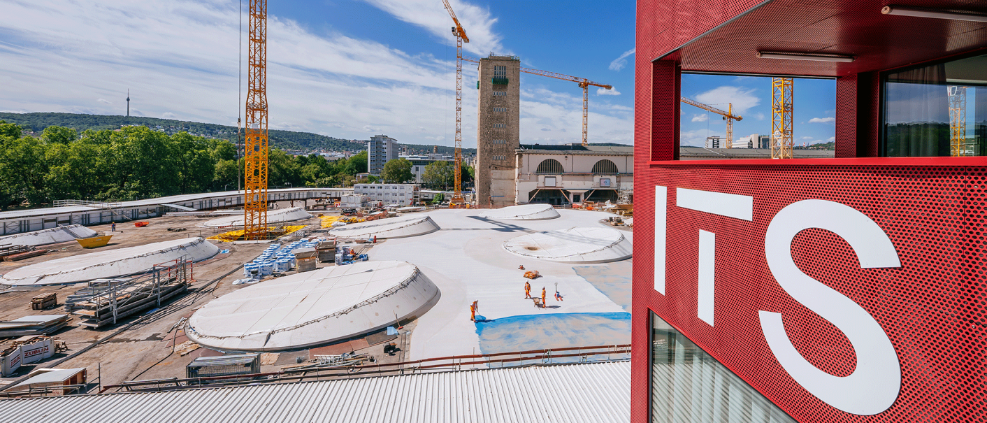 View of a construction site with several cranes and a red building with the inscription 'ITS' in the foreground., &copy; Thomas Niederm&uuml;ller