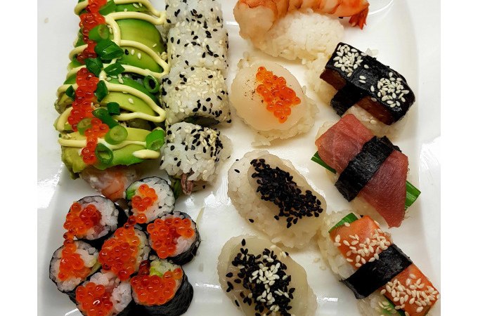 A plate with different sushi variations, including nigiri with prawns, salmon and tuna, as well as maki rolls with avocado and fish roe., &copy; Kultweine-Kochwelten-Kunst&uuml;cke - Kochschule Sonja Lenz