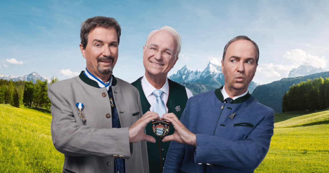 Drei M&auml;nner in bayerischer Tracht posieren vor einer malerischen Berglandschaft. Sie formen mit ihren H&auml;nden ein Herz um ein bayerisches Wappen., &copy; Severin Schweiger