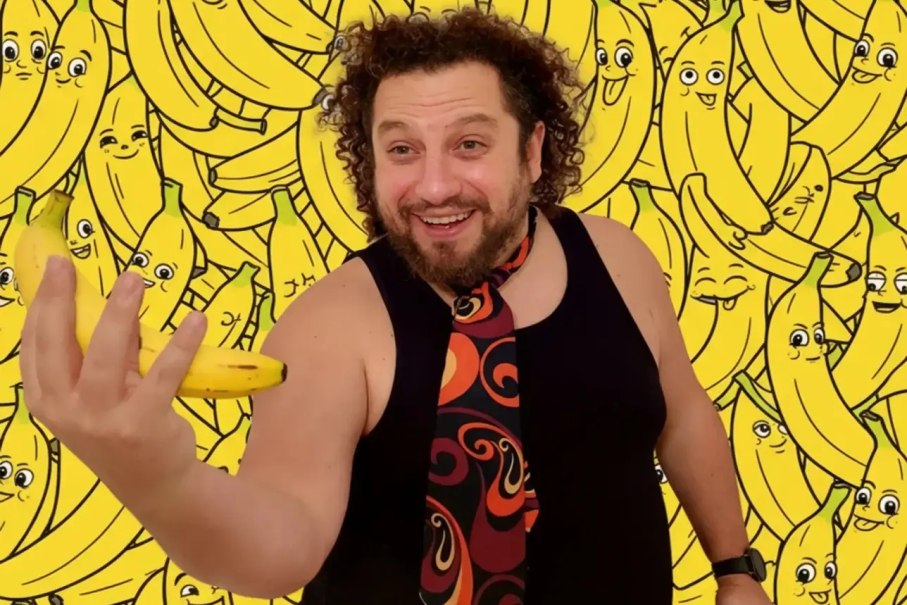Ein Mann mit lockigem Haar hält eine Banane in der Hand. Im Hintergrund sind viele gezeichnete Bananen mit Gesichtern zu sehen., © Theater am Olgaeck Ein Mann mit lockigem Haar hält eine Banane in der Hand. Im Hintergrund sind viele gezeichnete Bananen mit Gesichtern zu sehen., © Theater am Olgaeck