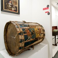 Museumsausstellung mit historischen Musikinstrumenten, darunter eine bemalte Trommel im Vordergrund und verschiedene Tasteninstrumente im Hintergrund., © Landesmuseum Württemberg Museumsausstellung mit historischen Musikinstrumenten, darunter eine bemalte Trommel im Vordergrund und verschiedene Tasteninstrumente im Hintergrund., © Landesmuseum Württemberg