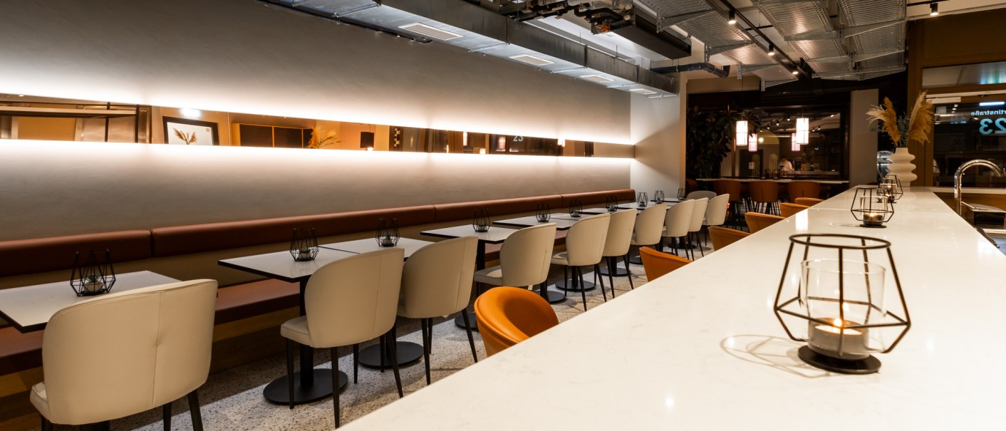 Ein modernes Restaurant mit weißen Tischen und Stühlen, stilvoller Beleuchtung und dekorativen Elementen. Die Atmosphäre wirkt einladend und elegant., © GINN Apartments Esslingen Ein modernes Restaurant mit weißen Tischen und Stühlen, stilvoller Beleuchtung und dekorativen Elementen. Die Atmosphäre wirkt einladend und elegant., © GINN Apartments Esslingen