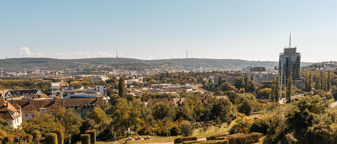 Panoramablick auf Stuttgart mit dem Fernsehturm im Hintergrund und modernen Gebäuden im Vordergrund. Die Stadt ist von grünen Hügeln umgeben., © Stuttgart-Marketing GmbH, Sarah Schmid