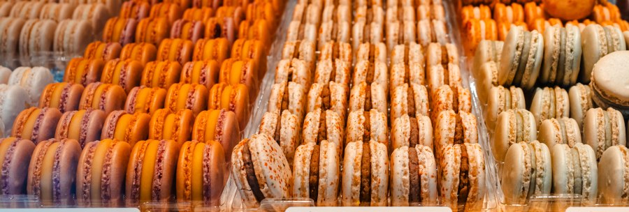 Macarons in various flavors such as vanilla, carrot and Aperol orange presented in a display., © SMG, Sarah Schmid