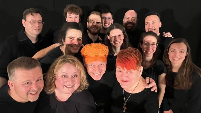 Eine fröhliche Gruppe von Menschen posiert vor einem schwarzen Hintergrund. Sie tragen schwarze Kleidung und lächeln in die Kamera., © kaba-reh prodcution Eine fröhliche Gruppe von Menschen posiert vor einem schwarzen Hintergrund. Sie tragen schwarze Kleidung und lächeln in die Kamera., © kaba-reh prodcution