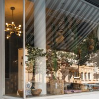 Schaufenster eines Gesch&auml;fts namens 'Von Herzen', dekoriert mit Pflanzen, Lampen und K&ouml;rben. Die Spiegelung zeigt eine Stra&szlig;e mit Geb&auml;uden., &copy; SMG, Sarah Schmid