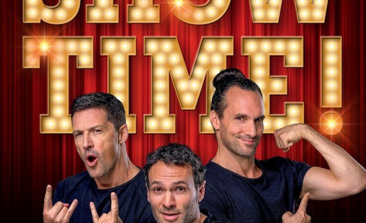 Drei Männer in schwarzen T-Shirts posieren vor einem beleuchteten 'SHOWTIME!' Schild auf rotem Hintergrund., © Theaterhaus Stuttgart e.V.