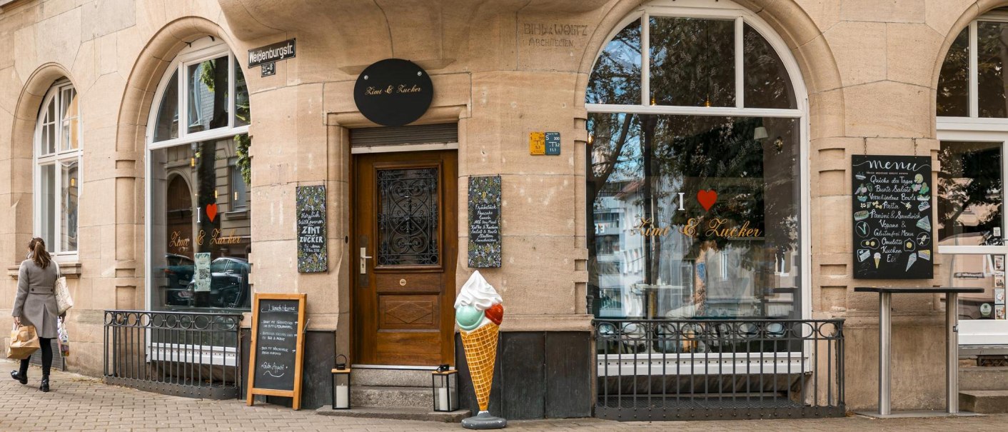 A café called 'Zimt & Zucker' on a street corner with large windows, an ice cream cone model and a woman walking past., © SMG Stuttgart Marketing GmbH - Sarah Schmid