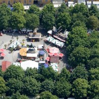 Aerial view of Karlsplatz in Stuttgart. Market stalls and colorful umbrellas are surrounded by trees. An equestrian statue stands in the center., &copy; Stuttgart-Marketing GmbH