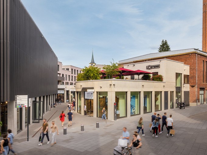 Einkaufsstraße in der Outletcity Metzingen mit modernen Gebäuden, Geschäften und vielen Passanten bei sonnigem Wetter., © Schlienz-Tours GmbH & Co.KG Einkaufsstraße in der Outletcity Metzingen mit modernen Gebäuden, Geschäften und vielen Passanten bei sonnigem Wetter., © Schlienz-Tours GmbH & Co.KG