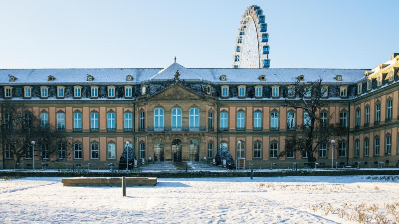 Das Neue Schloss in Stuttgart ist von Schnee bedeckt. Im Hintergrund ist ein Riesenrad zu sehen, das in den blauen Himmel ragt., &copy; Stuttgart-Marketing GmbH, Sarah Schmid