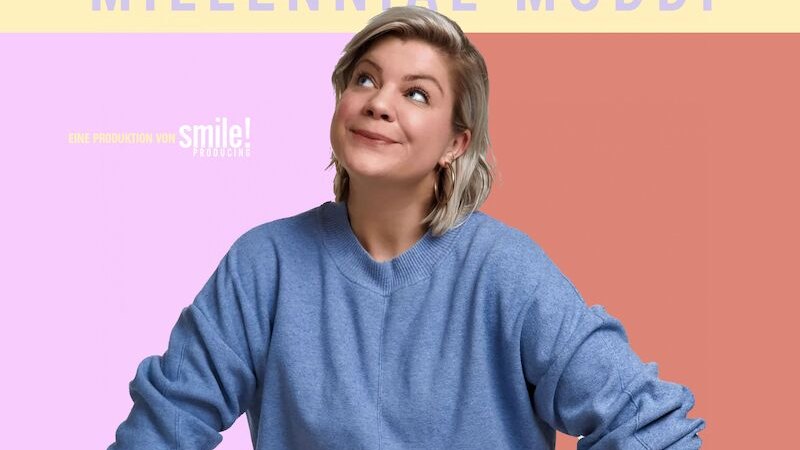 Frau in blauem Pullover schaut nach oben vor einem bunten Hintergrund. Oben steht 'Frieda Lewin Millennial Muddi'. Unten sind verschiedene Symbole., © Konzertbüro Schoneberg GmbH Frau in blauem Pullover schaut nach oben vor einem bunten Hintergrund. Oben steht 'Frieda Lewin Millennial Muddi'. Unten sind verschiedene Symbole., © Konzertbüro Schoneberg GmbH