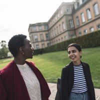 Two people are walking and talking in front of a historic building with a well-tended lawn in the background., © Stuttgart-Marketing GmbH, wpsteinheisser Two people are walking and talking in front of a historic building with a well-tended lawn in the background., © Stuttgart-Marketing GmbH, wpsteinheisser