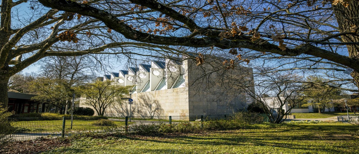 The museum in the Kleinhues building with its striking architecture, surrounded by trees and a fence, in sunny weather., © SMG Stuttgart Marketing GmbH - Sarah Schmid