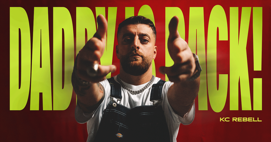 Person in Latzhose zeigt mit den H&auml;nden auf die Kamera. Im Hintergrund steht in gro&szlig;en gelben Buchstaben 'Daddy is back!'., &copy; links im Bild