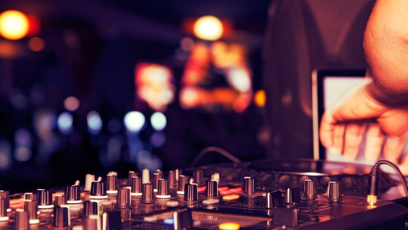 Ein DJ-Mischpult mit vielen Reglern und einer Hand, die es bedient. Im Hintergrund sind bunte Lichter und verschwommene Formen zu sehen., © Planetarium Stuttgart Ein DJ-Mischpult mit vielen Reglern und einer Hand, die es bedient. Im Hintergrund sind bunte Lichter und verschwommene Formen zu sehen., © Planetarium Stuttgart