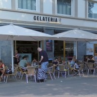 Menschen sitzen unter Sonnenschirmen vor der Gelateria Kaiserbau am Marienplatz. Einige Passanten gehen vorbei., &copy; Stuttgart-Marketing GmbH