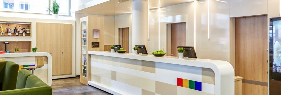 Modern lobby with white reception desk, green armchairs and bar area. Bright lighting and decorative plants create an inviting atmosphere., © Park Inn by Radisson Stuttgart Modern lobby with white reception desk, green armchairs and bar area. Bright lighting and decorative plants create an inviting atmosphere., © Park Inn by Radisson Stuttgart