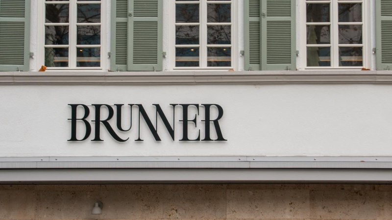 Lettering on the facade of the Brunner restaurant with serifs. Above it, lattice windows with green shutters., &copy; SMG, Sarah Schmid