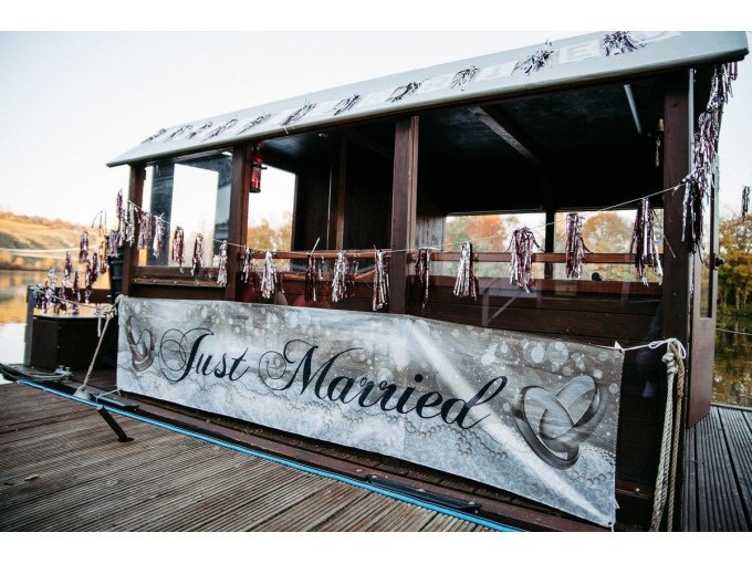 A boat on the jetty, decorated with a 'Just Married' banner and garlands, surrounded by an autumnal landscape., © Cool-Tours StattReisen A boat on the jetty, decorated with a 'Just Married' banner and garlands, surrounded by an autumnal landscape., © Cool-Tours StattReisen