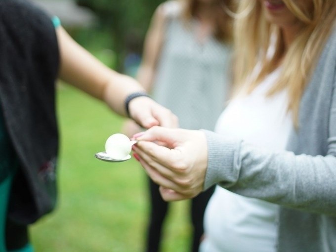 Zwei Personen spielen ein Ei-und-L&ouml;ffel-Spiel im Freien. Eine Person h&auml;lt den L&ouml;ffel mit einem Ei, die andere hilft dabei., &copy; Cool-Tours StattReisen