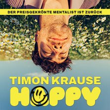 Ein Mann liegt kopf&uuml;ber auf einer Blumenwiese. Der Text 'Timon Krause HAPPY' ist in gelber Schrift zu sehen., &copy; links im Bild