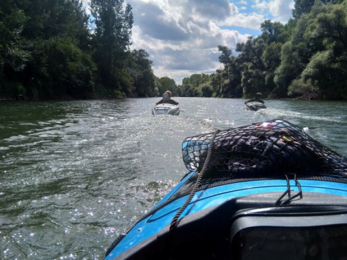 Two boats are sailing on a river, surrounded by lush trees. The sky is cloudy and the scene appears calm and idyllic., &copy; Cool-Tours StattReisen