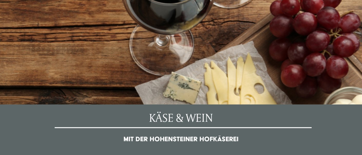 Ein Glas Rotwein, K&auml;sescheiben, Blauschimmelk&auml;se und rote Trauben auf einem Holztisch. Text: K&auml;se & Wein mit der Hohensteiner Hofk&auml;serei., &copy; Weinmanufaktur Stuttgart eG