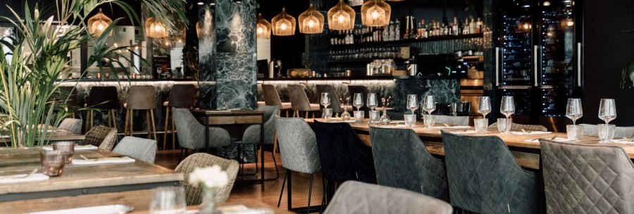 Elegantes Restaurant mit modernen Möbeln, gedeckten Tischen und stilvoller Bar im Hintergrund. Dezente Beleuchtung und Pflanzen sorgen für eine gemütliche Atmosphäre., © Malo Stuttgart - Lea Prestle