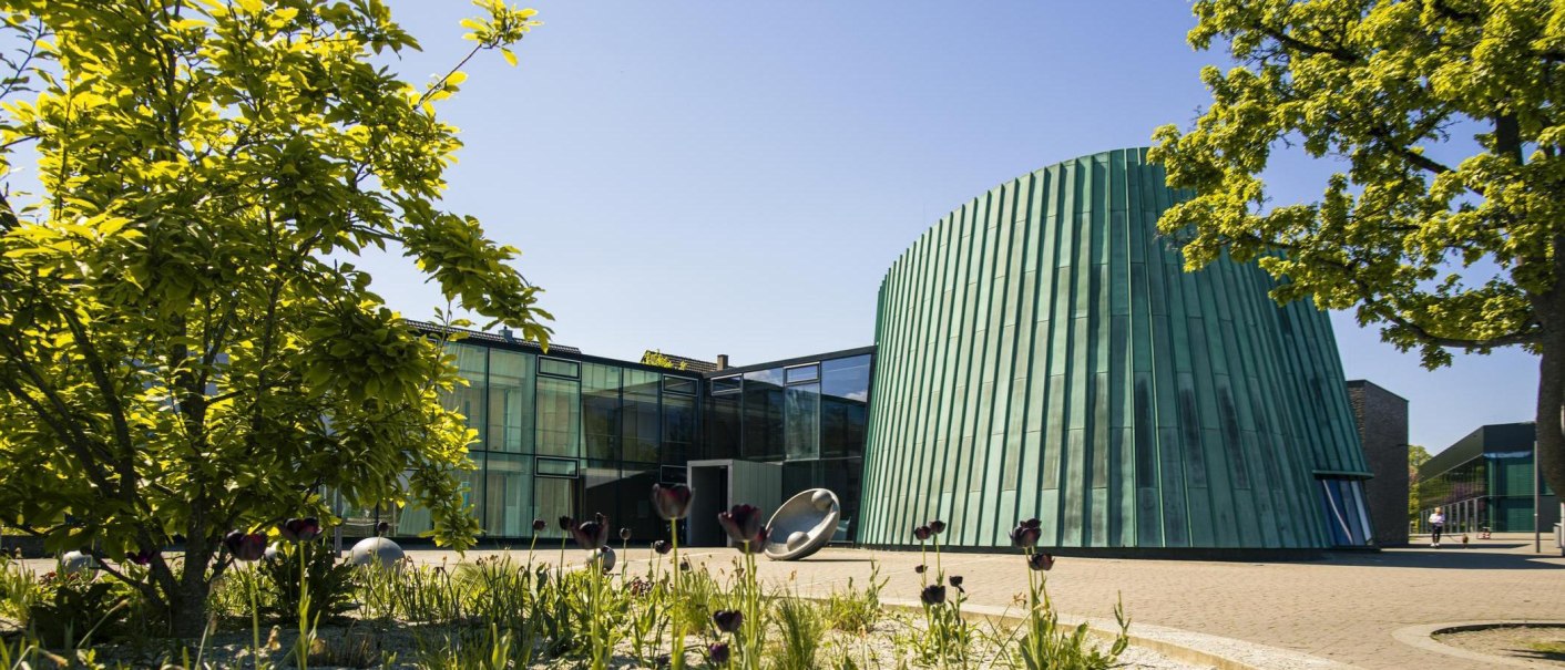 The Fellbach Music School features modern architecture, with a green, conical building and glass facades, surrounded by trees and flowers., © SMG Stuttgart Marketing GmbH - Sarah Schmid The Fellbach Music School features modern architecture, with a green, conical building and glass facades, surrounded by trees and flowers., © SMG Stuttgart Marketing GmbH - Sarah Schmid