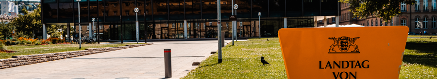 The state parliament of Baden-W&uuml;rttemberg with a modern glass fa&ccedil;ade and a yellow sign in the foreground. The television tower can be seen in the background., &copy; Stuttgart-Marketing GmbH, Sarah Schmid